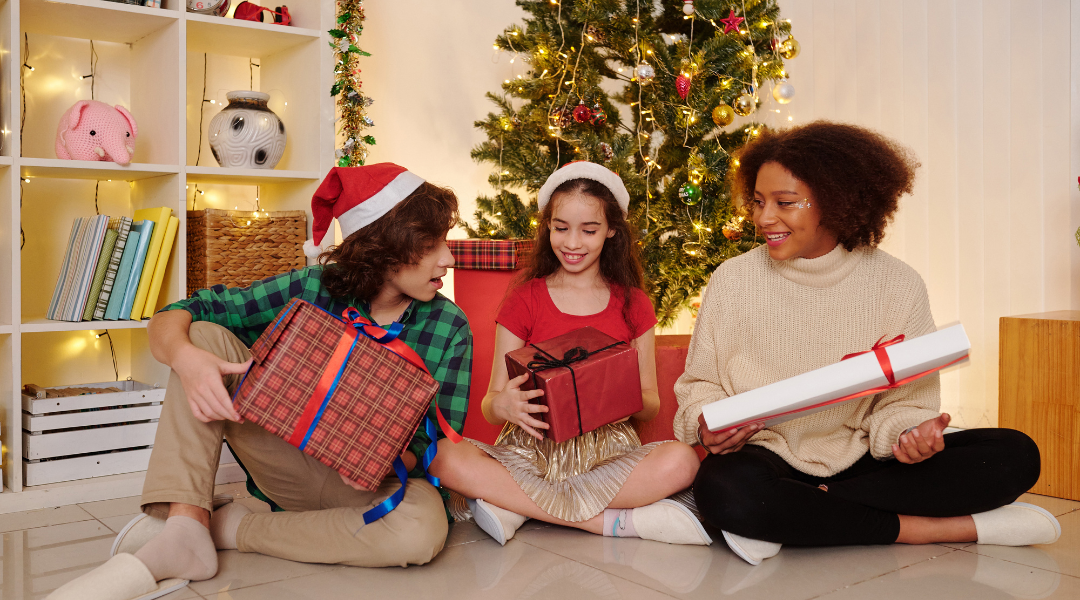 Three children holding Christmas presents