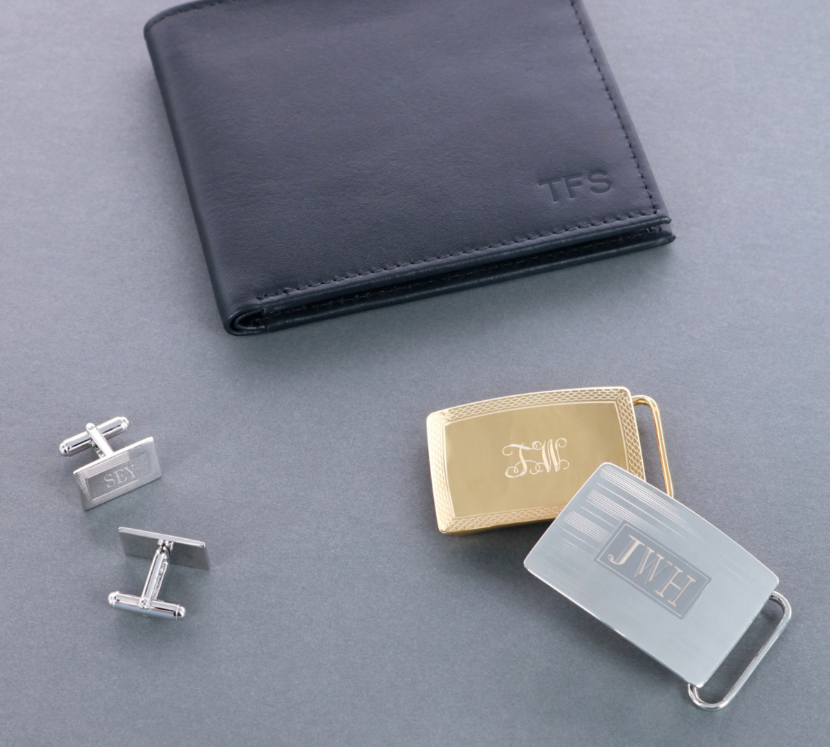 A wallet, buckles, and cufflinks with monograms