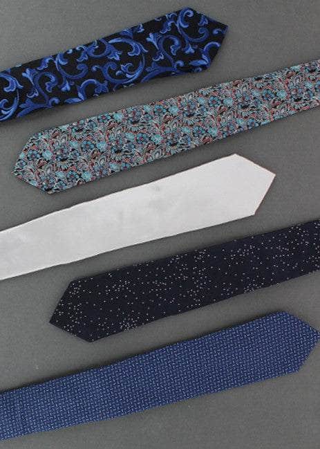 Five patterned ties arranged on a gray surface